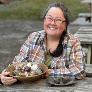 Karen Dubois headshot with finished pots, small fruit