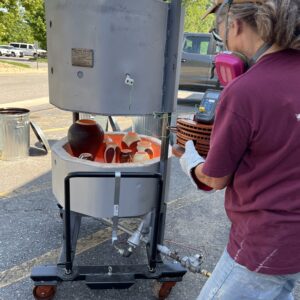 Judi Pulling Pots from Raku Kiln